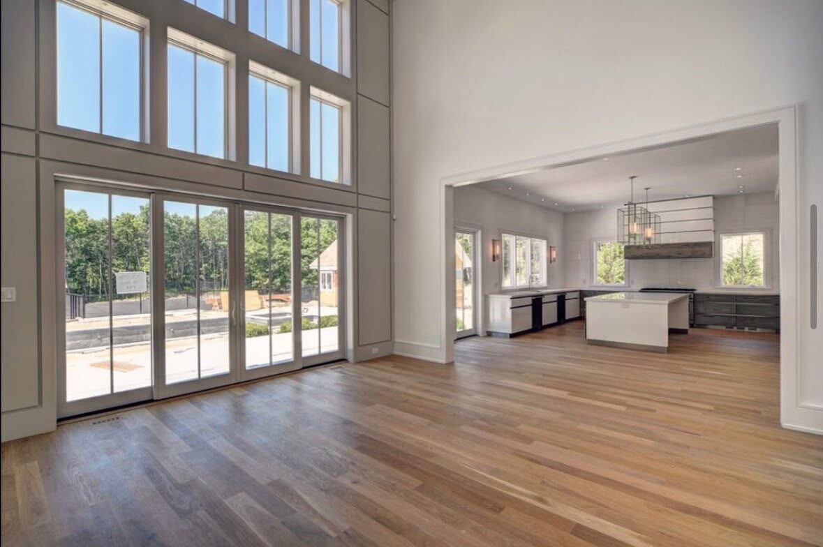 Double-height window wall with paneled trim and cased openings