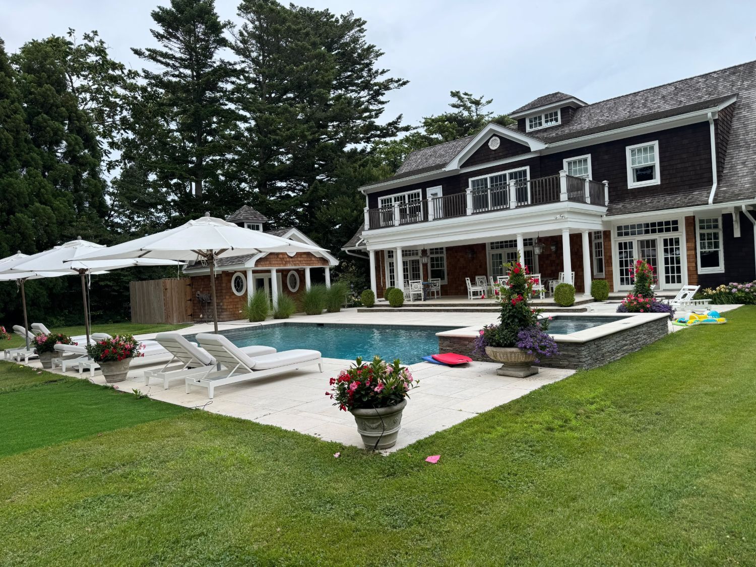 Shingle-style home with a pool and covered porch in the Hamptons