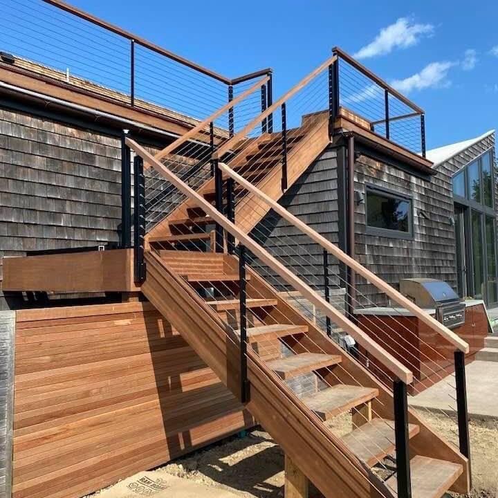Exterior hardwood stair and deck with cable railing.