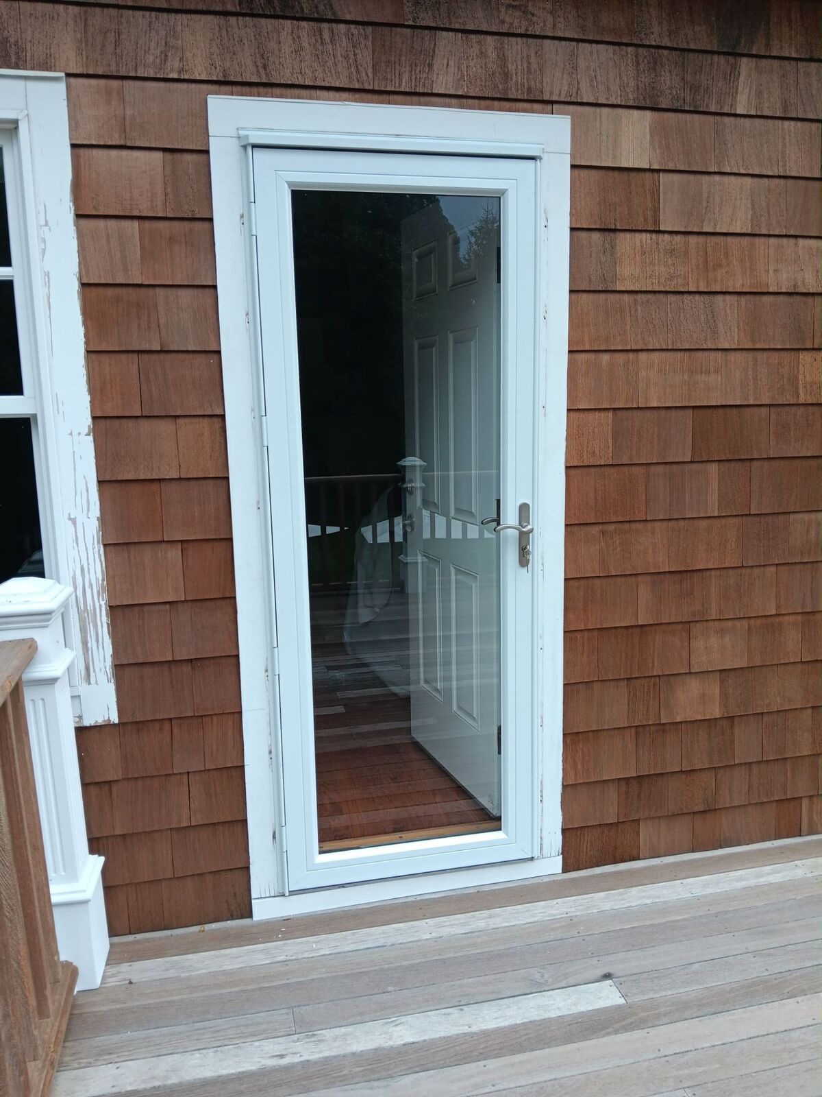 Storm door installed in a cedar-shingle wall